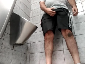A busy guy with an uncut dick peeing in a public toilet